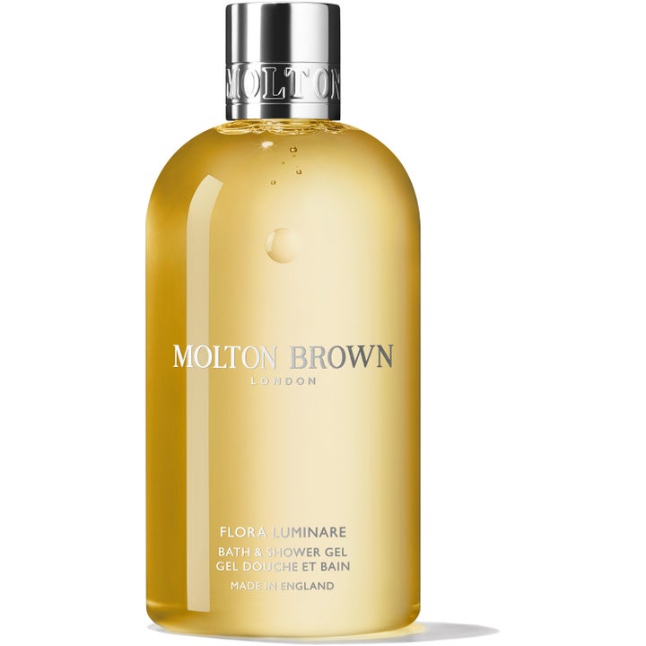 Molton Brown Flora Luminare 300 ml rengjørende dusjsåpe i klar flaske med gyllen gelé og elegant sølvfarget kork.