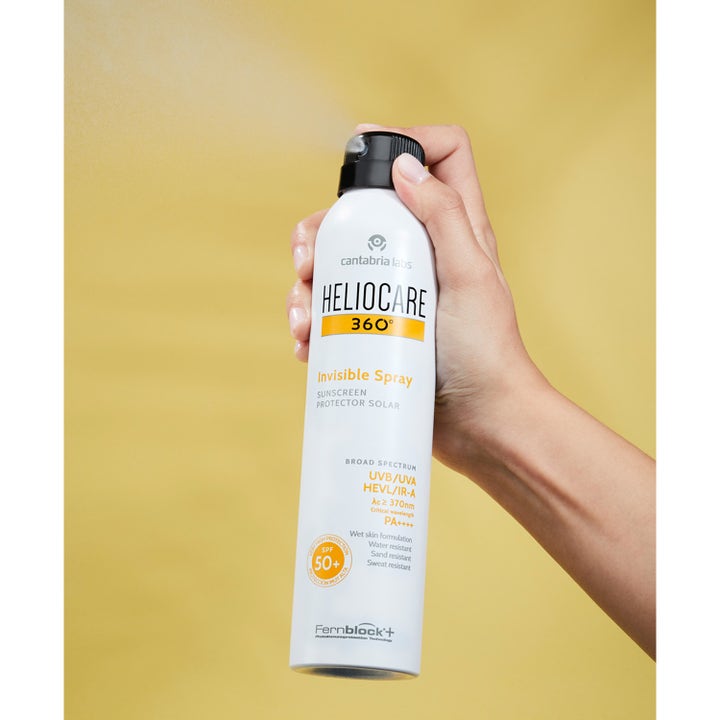 Heliocare Invisible Spray SPF 50+ 200 ml solspray gir høy solbeskyttelse i hvit flaske som sprayes av en hånd.