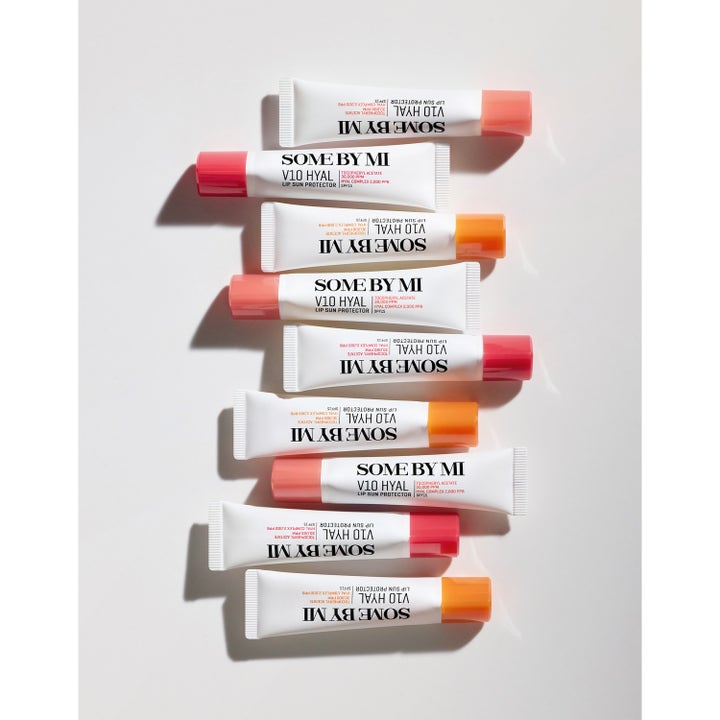 Some By Mi V10 Hyal Lip Protector 7 ml er en pleiende leppeprodukt i hylse som ligger i en dekorativ rekke.