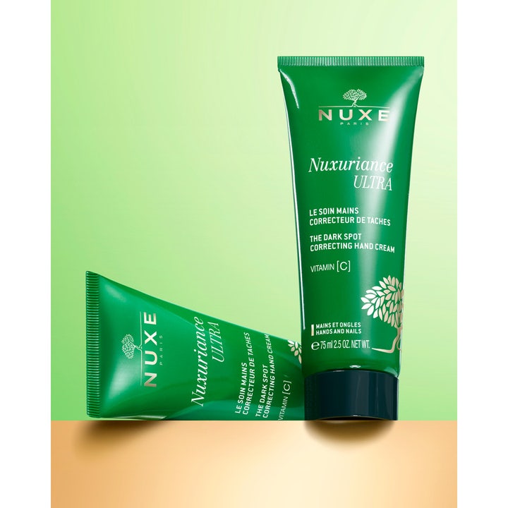 Nuxe Nuxuriance Ultra Hand Cream 90 g mot mørke flekker vist som to grønne tuber med vitamin C og gylne detaljer