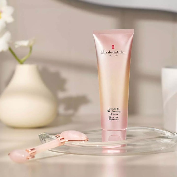 Elizabeth Arden Ceramide Skin Renewing Cleanser 125 ml ansiktsrengjøring i rosa tube på et glassfat med ansiktsrulle
