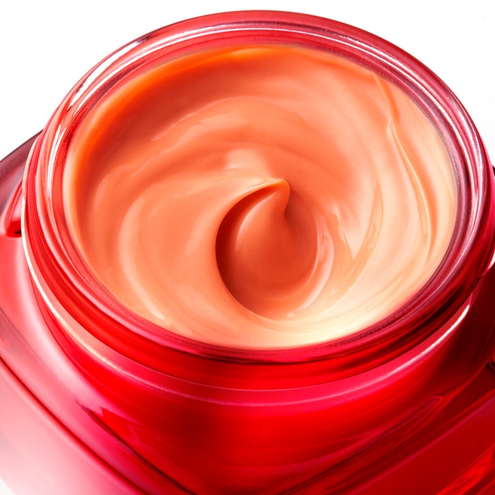L'Oréal Paris Revitalift Ginseng Glow 50 ml dagkrem i rød glasskrukke med en kremet ferskenfarget tekstur som gir glød.