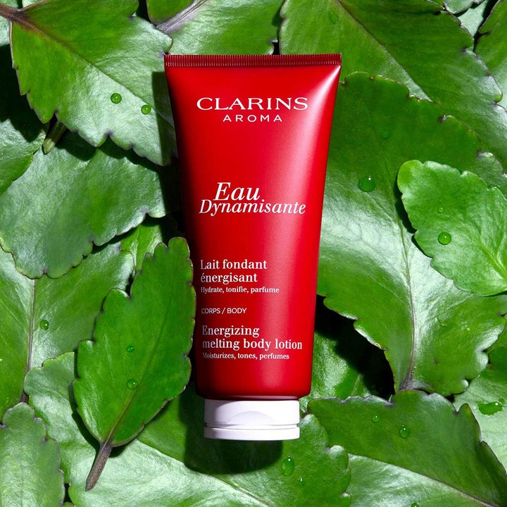 Clarins Eau Dynamisante Energizing Melting Body Lotion 200 ml gir fukt i rød tube på store grønne blader