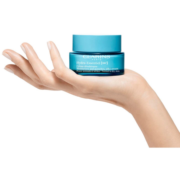 Clarins Hydra-Essentiel Silky Cream 50 ml fuktighetsgivende dagkrem i en blå krukke i en åpen håndflate