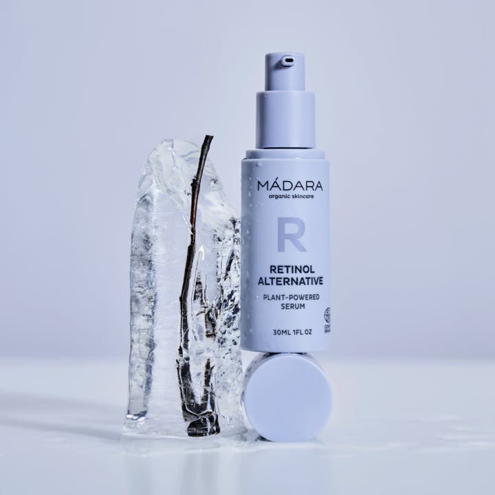 MÁDARA Retinol Alternative Serum 30 ml hudpleie i lys lilla pumpeflaske plassert ved siden av en isblokk.