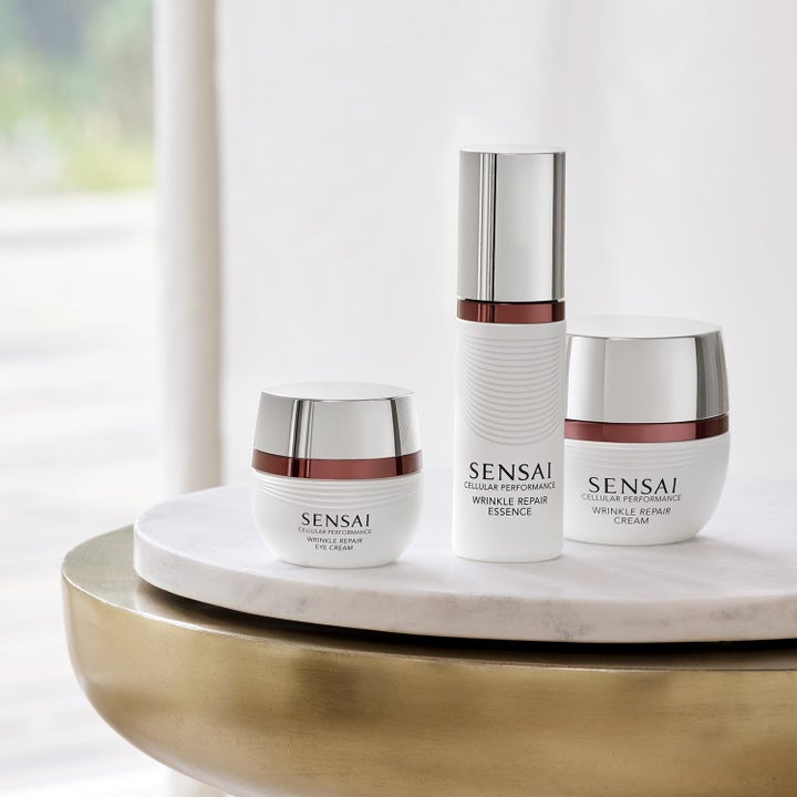 Sensai Cellular Performance Wrinkle Repair hudpleiesett mot rynker med hvite krukker og flaske med sølvdetaljer.