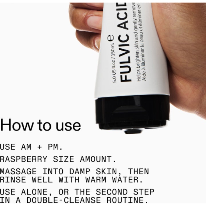 The INKEY List Fulvic Acid Cleanser 150 ml ansiktsrens i hvit tube holdt av en hånd over instruksjoner for bruk
