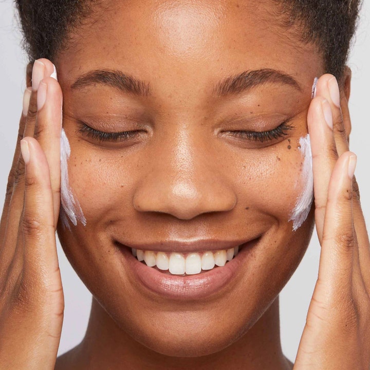 Dermalogica Invisible Physical Defense SPF30 50 ml solkrem til ansikt påføres på kinnene til en smilende kvinne