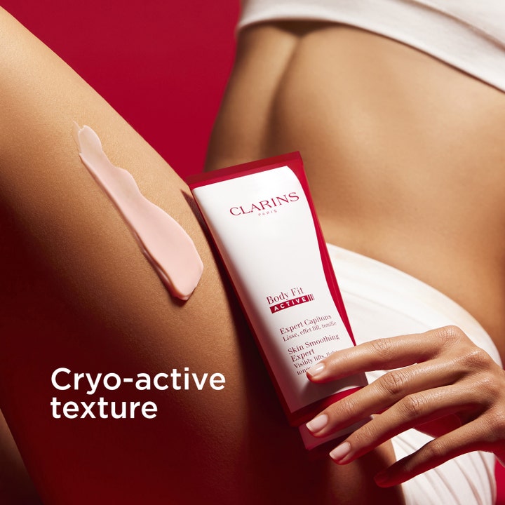 Clarins Body Fit Active 200 ml oppstrammende bodylotion viser rosa cryo-active tekstur på et lår og hvit tube.