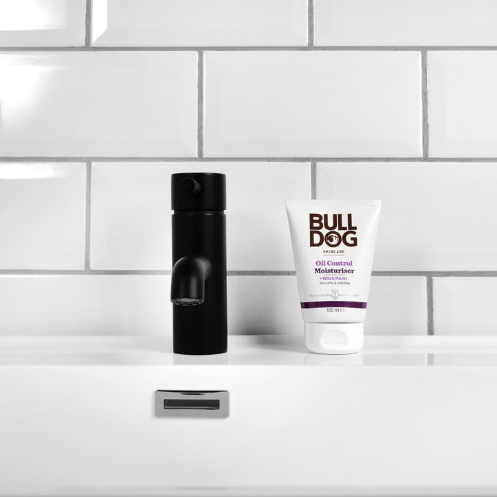 Bulldog Oil Control Moisturiser 100 ml mattende ansiktskrem på hvit tube ved siden av en sort kran