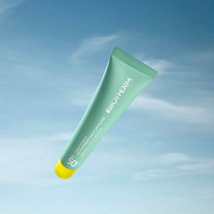 Biotherm Aquascreen Activewear Daily UV Fluid 40 ml solkrem i lysegrønn tube med gult lokk mot en blå himmel.