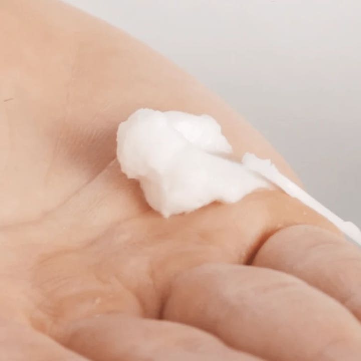 Codage Paris The Scrubbing Cream 50 ml eksfolierende ansiktskrem viser en hvit fyldig tekstur på en hånd
