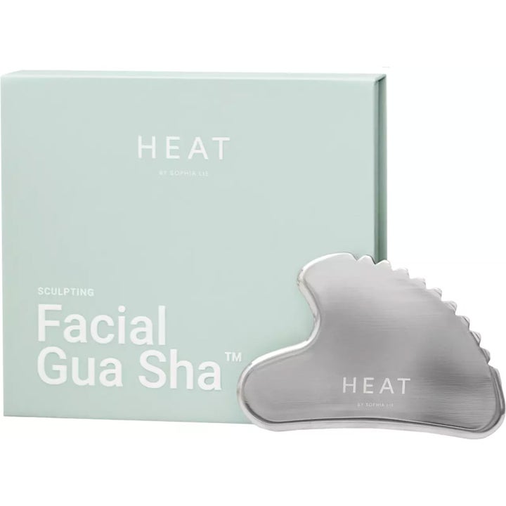 HEAT by Sophia Lie Facial Gua Sha 1 stk ansiktsverktøy i stål ved siden av lysegrønn eske for skulpturering