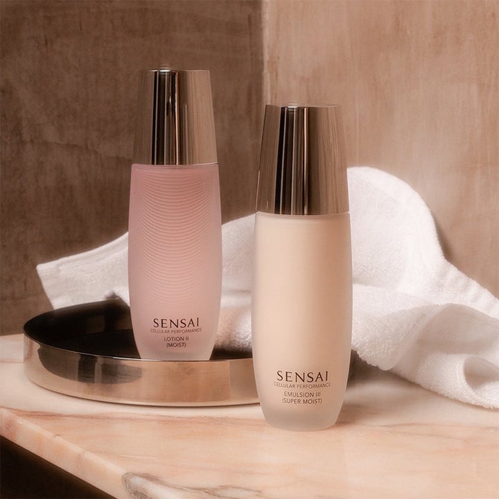 Sensai Moisture &amp; Cleanse Combo fuktighetsgivende ansiktspleie i frostede flasker på et sølvfat med hvitt håndkle.