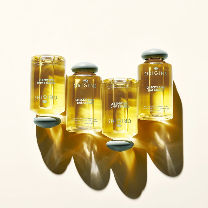 Origins Checks & Balances Milky Oil Cleanser 150 ml renseolje fjerner sminke vist i fire flasker med gyllen olje.