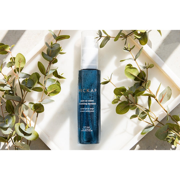 Hickap Pure As Snow Cleansing Mousse 150 ml vegansk rengjøringsskum i blå flaske omgitt av grønne eukalyptusblader