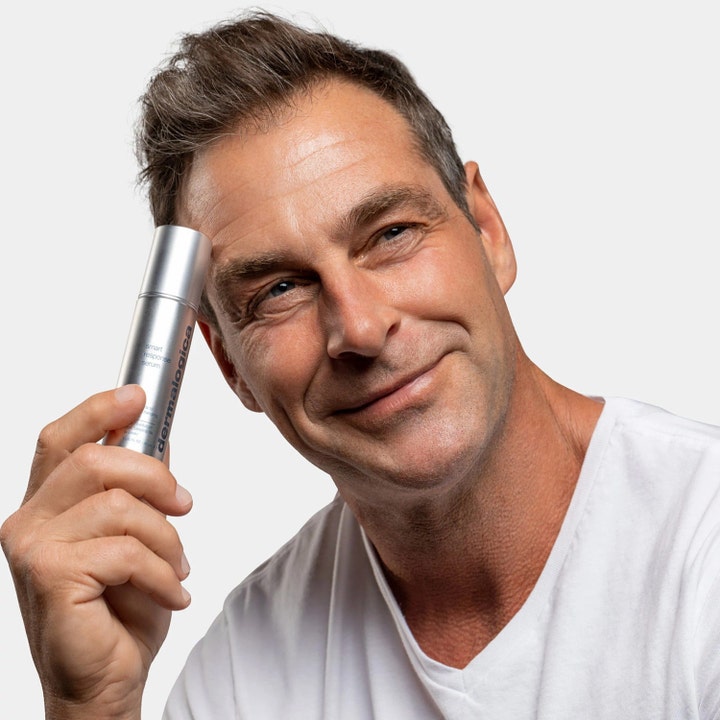 Dermalogica Smart Response Serum 30 ml fuktighetsgivende ansiktsserum i sølvflaske holdt av en smilende mann.