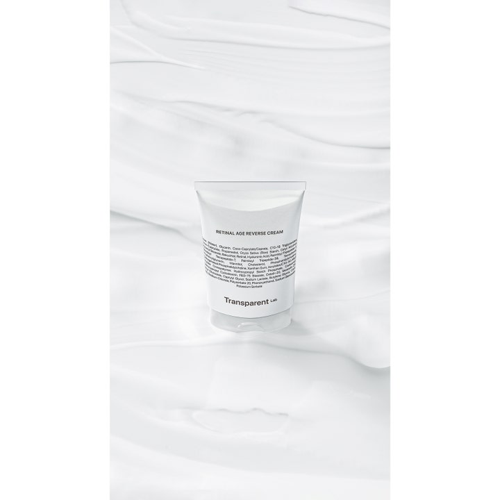 Niche Beauty Lab Transparent Lab Retinal Age Reverse Cream 50 ml i hvit tube mot bølgende hvitt stoff
