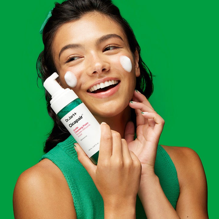 Dr.Jart+ Cicapair Gentle Cleansing Foam 150 ml beroligende ansiktsrens vist av smilende kvinne med hvitt skum på kinnene.