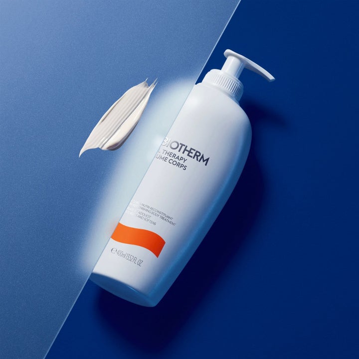 Biotherm Baume Corps 400ml fuktighetsgivende kroppskrem i hvit pumpeflaske med fyldig hvit tekstur på blå bakgrunn