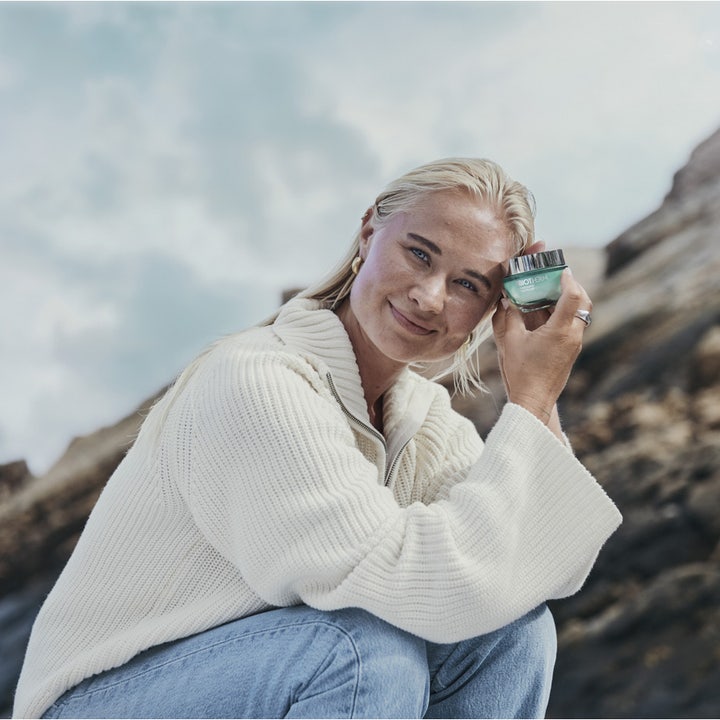Biotherm Aquasource Hyalu Plump 30 ml fuktighetsgivende dagkrem i grønn glasskrukke holdt av kvinne utendørs