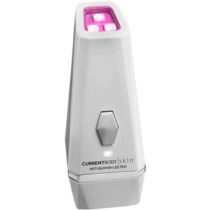 CurrentBody Skin Anti-Blemish LED Pen mot urenheter hvit håndholdt penn med sølvdetaljer og rosa lysende LED-dioder.