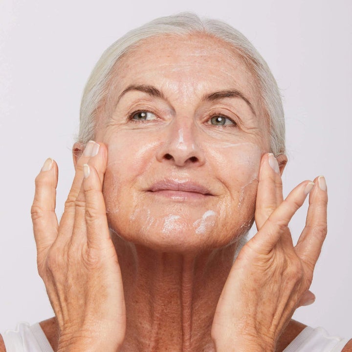 Dermalogica AGE smart Duo Super Rich Repair nærende ansiktskrem som en eldre kvinne masserer inn i huden