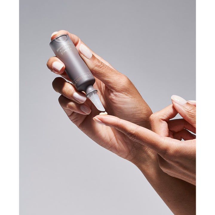 Exuviance Wrinkle Smooth Topical Peptide 5 g serum mot rynker som påføres fra en grå tube til en fingertupp.