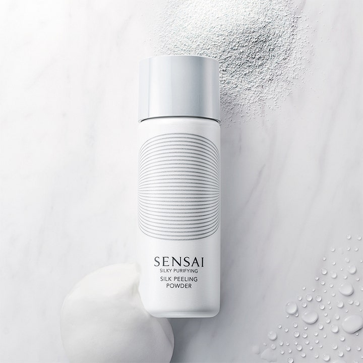 Sensai Silky Purifying Silk Peeling Powder 40 g ansiktspeeling i hvit flaske vist med pulver og skum på marmor