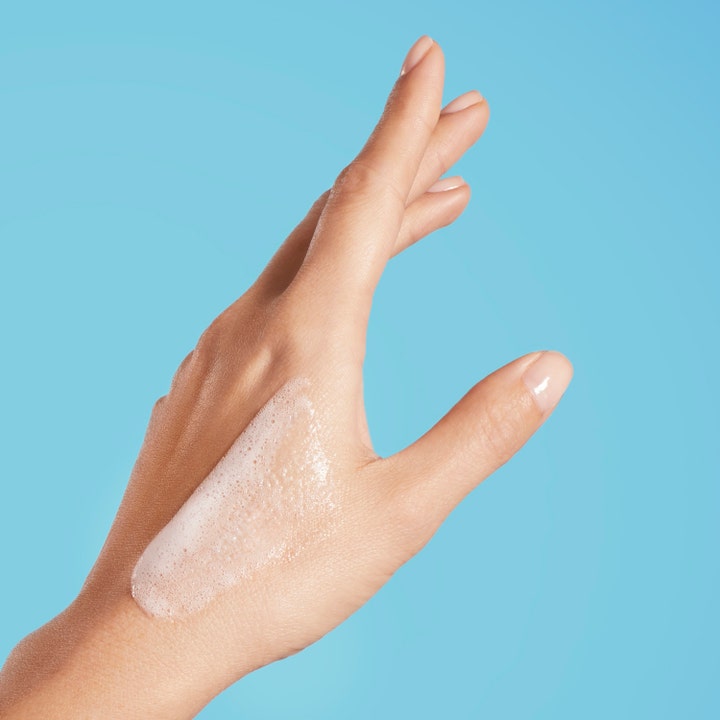 Biotherm Oil Therapy Baume Corps 200 ml fuktighetsgivende dusjolje med lett skummende tekstur på en hånd