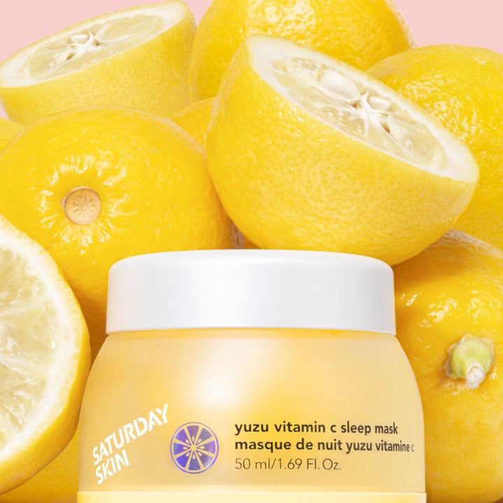 Saturday Skin Yuzu Vitamin C Sleep Mask 50 ml glødgivende nattmaske i gul krukke omgitt av friske sitrusfrukter