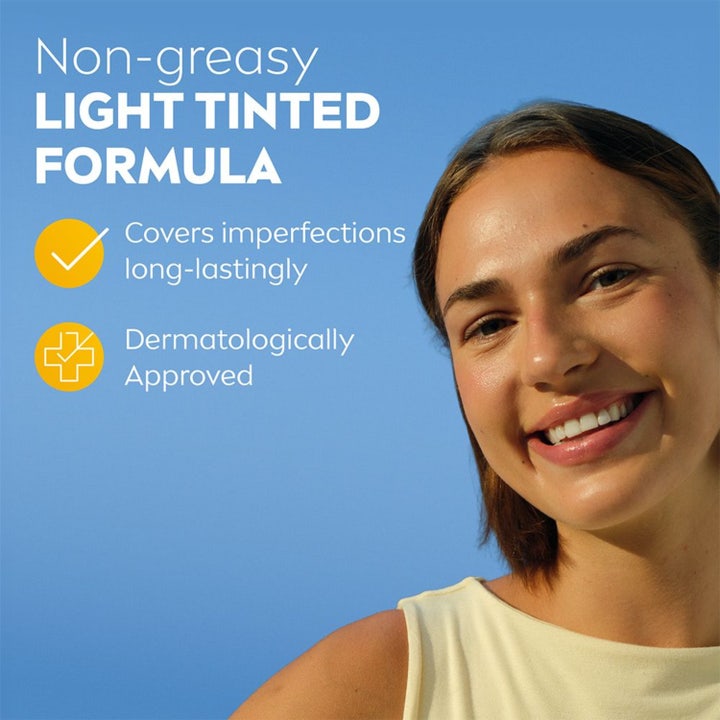 NIVEA UV Face Ultra Fluid Light Tinted SPF50+ 40 ml solkrem for ansiktet som dekker ujevnheter på en smilende kvinne