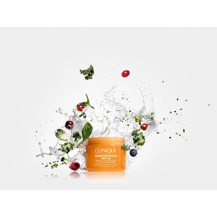 Clinique All-Day Defense 100 ml ansiktskrem med niacinamid i oransje krukke omgitt av sprutende bær og hvit krembølge