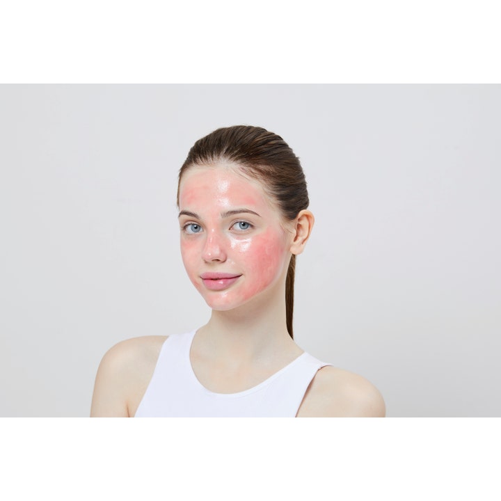 COSRX The AHA BHA PHA LHA 35 Peel 30 ml eksfolierende ansiktspeeling påført som en rosa maske på en kvinnes ansikt