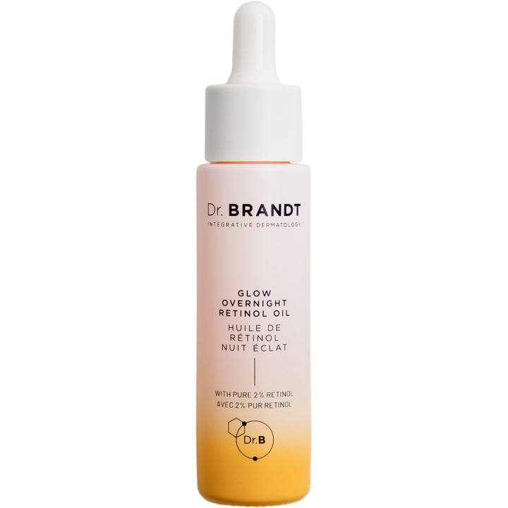Dr. Brandt Glow Overnight Retinol Oil fornyende ansiktsolje i en hvit og gul gradientflaske med hvit pipette.