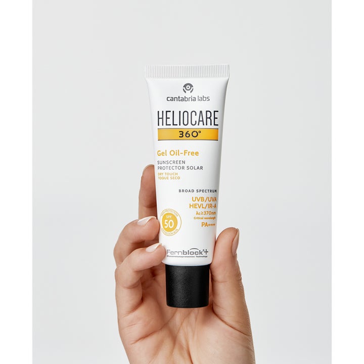 Heliocare Gel Oil Free SPF 50+ 50 ml solkrem gir mattende beskyttelse i hvit tube med svart kork som holdes i en hånd.