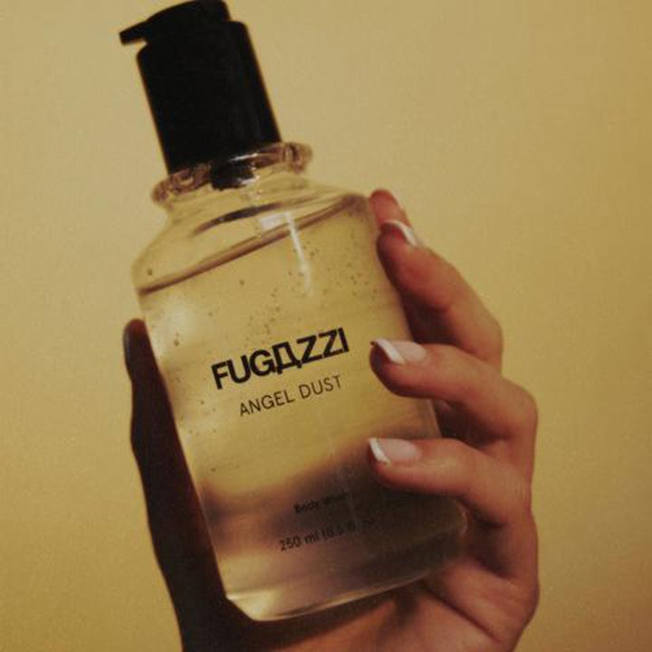 Fugazzi Angel Dust 250 ml rengjørende dusjsåpe i klar flaske med sort pumpe holdt i en hånd