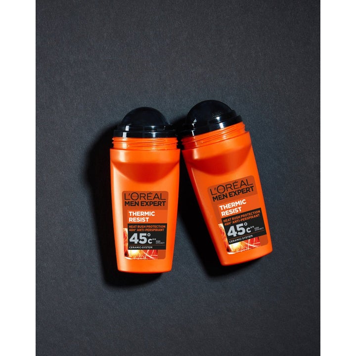 L'Oréal Paris Men Expert Thermic Resist roll-on deodorant med varmebeskyttelse i to oransje flasker på svart flate.