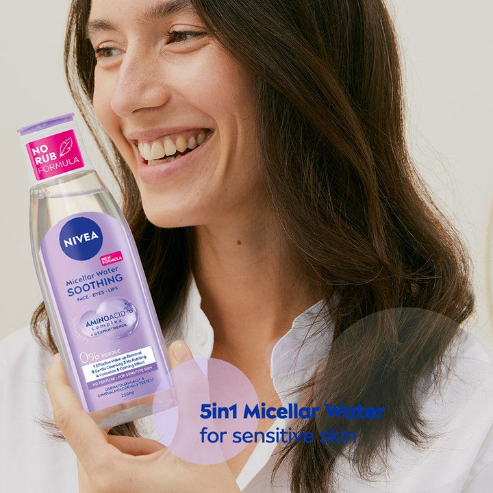 NIVEA Micellar Water Soothing 200 ml ansiktsrens holdes av smilende kvinne for skånsom sminkefjerning