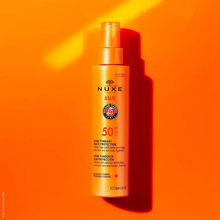 Nuxe Sun Face and Body Milk 184 g solkrem gir SPF50 beskyttelse i oransje sprayflaske med Roland Garros-logo