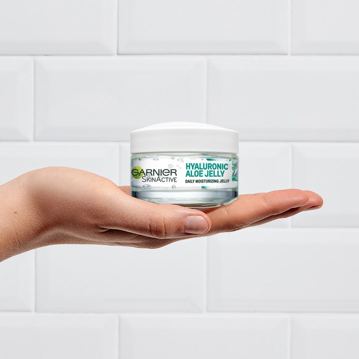 Garnier Hyaluron Barrier Repair Gelcreme 50 ml fuktighetsgivende gel i glasskrukke holdes i en hånd mot fliser