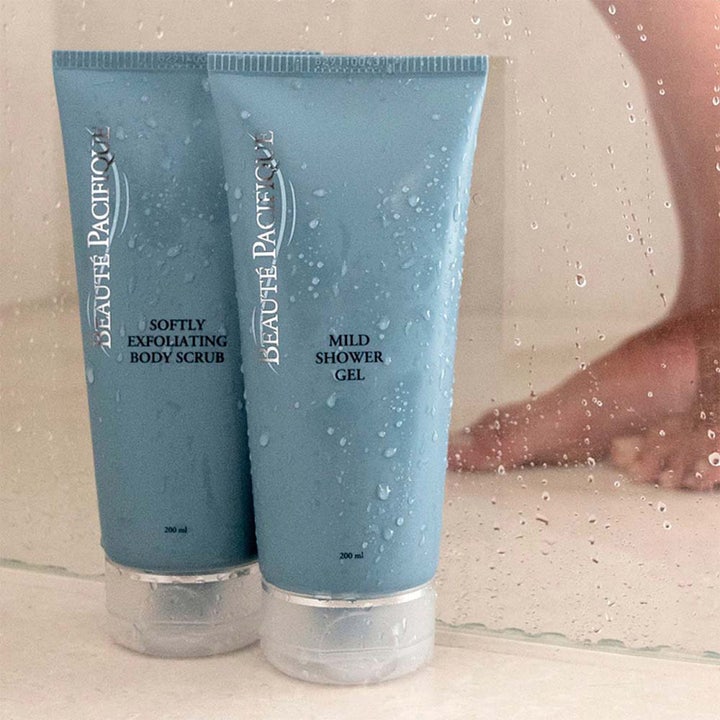 Beauté Pacifique Softly Exfoliating Body Scrub 200 ml gir glød i blå tuber med vanndråper i dusjen