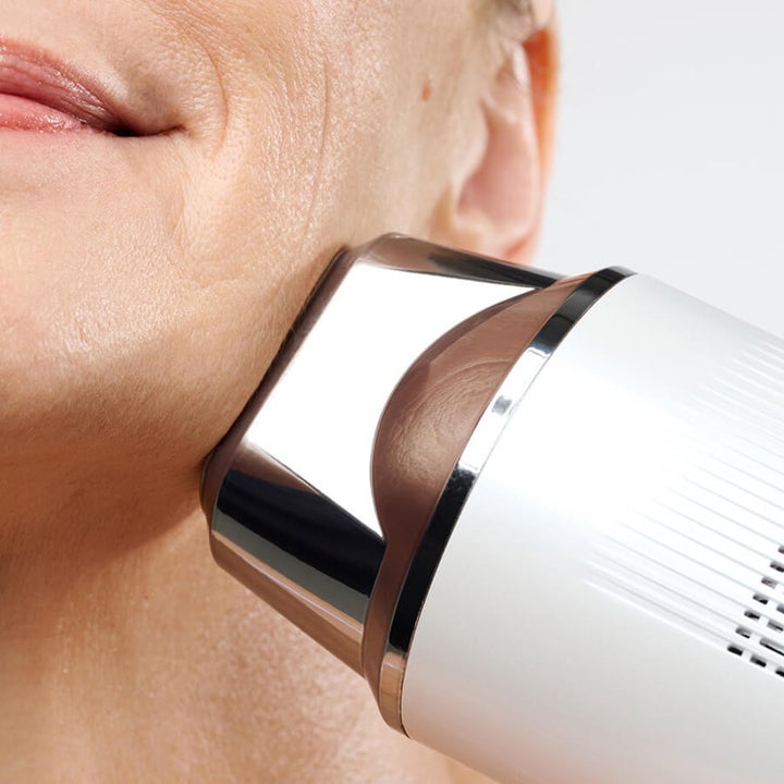 Currentbody Skin Laser Hair Removal Device hvit laserhårfjerner med kromdetaljer brukes mot huden på haken.