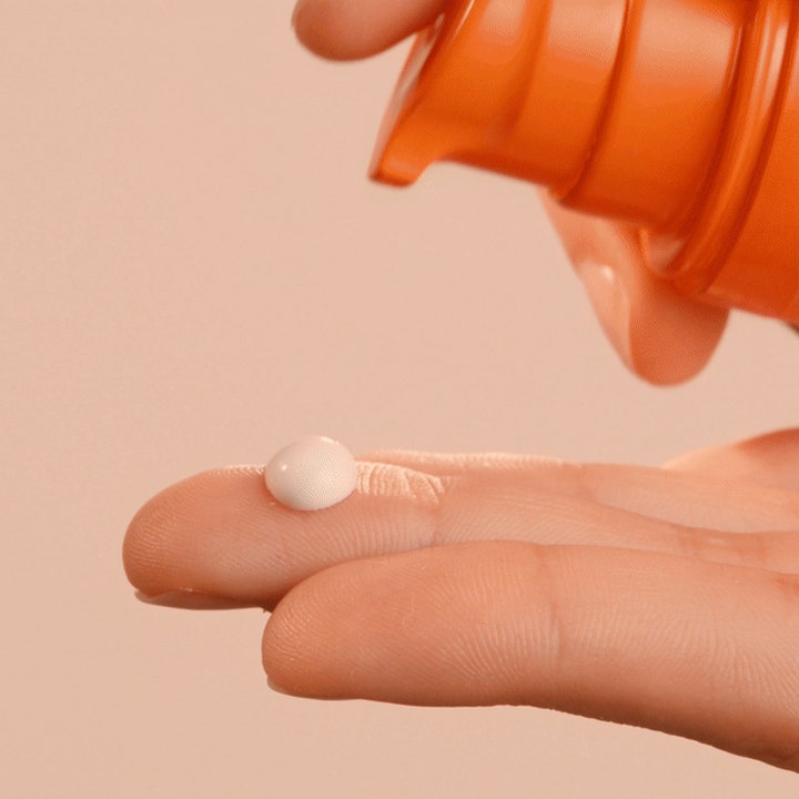 Lancaster Sun Care Face Fluid Cream 30 ml SPF30 solkrem for ansiktet gir beskyttelse med hvit tekstur på en fingertupp