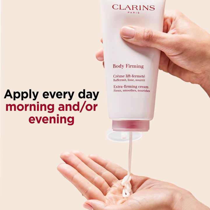 Clarins Body Firming Extra-Firming Cream 200 ml oppstrammende kroppskrem i hvit tube klemmes ut i en hånd