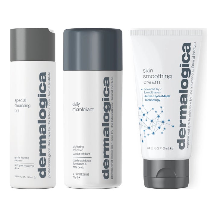Dermalogica hudpleiesett med rensende gel, eksfolierende pulver og fuktighetskrem i hvite flasker og tube.