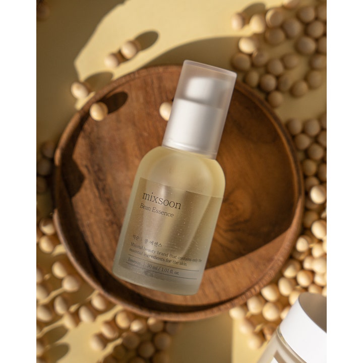 Mixsoon Bean Essence 30 ml fuktighetsgivende ansiktsserum i glassflaske på et trefat med soyabønner