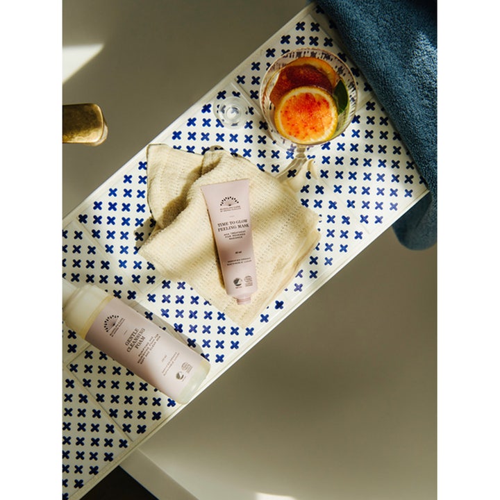 Rudolph Care Time to Glow Peeling Mask 50 ml ansiktsmaske i rosa tube på en lys klut med friske sitrusskiver i glass