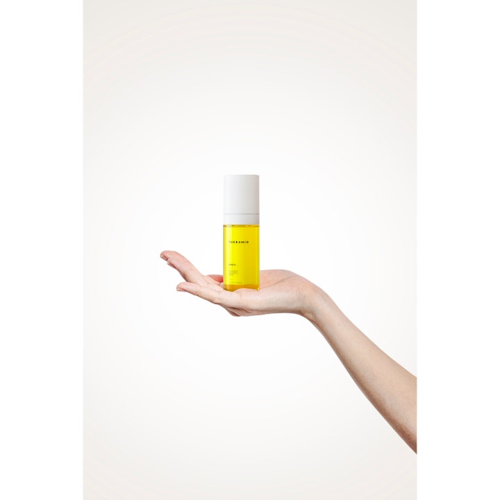 Niche Beauty Lab Theramid Lino 8 Antioxidant Treatment 30 ml gult serum i klar flaske holdt i en håndflate