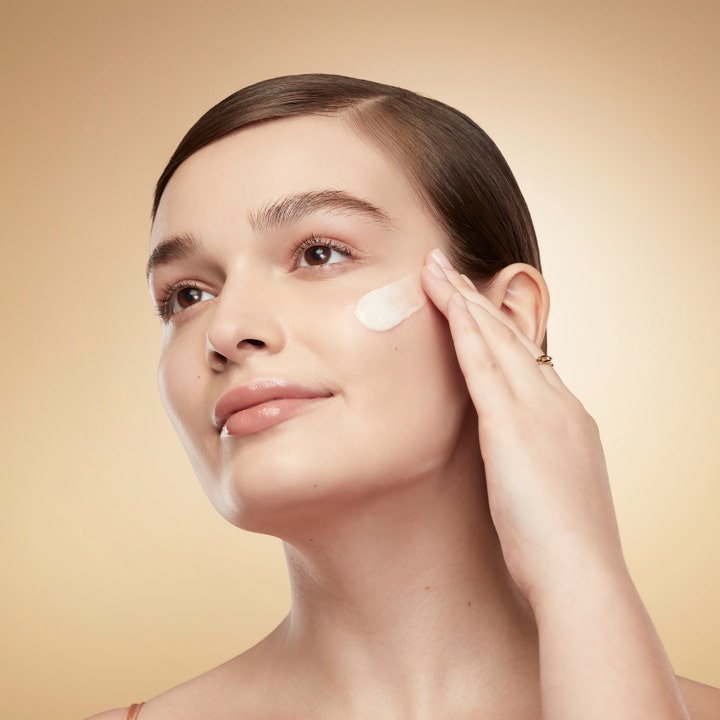 Estée Lauder Revitalizing Supreme+ Youth Power Creme 75ml dagkrem som kvinne påfører på kinnet for glød og fasthet.